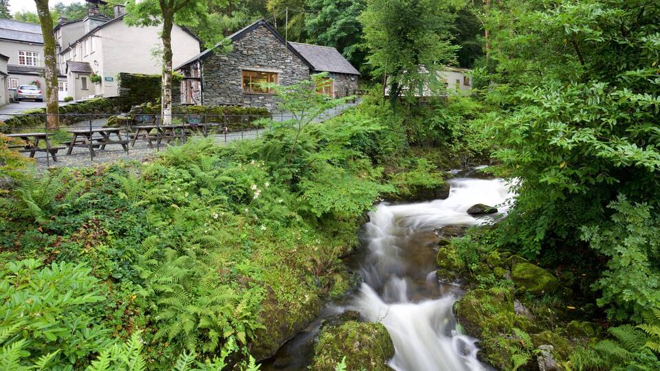 A stone house with a stone roof, a wooden fence, and a picnic table.