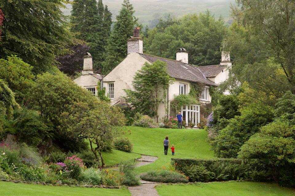 A quaint cottage surrounded by lush greenery and a well-maintained garden.