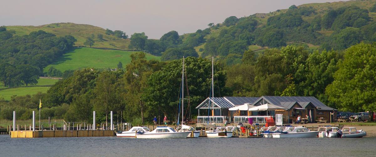 A marina with boats docked, a wooden pier, and a building with a sloped roof.