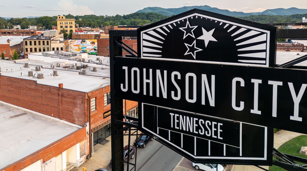 A sign for Johnson City, Tennessee, with a view of the cityscape and mountains in the background.