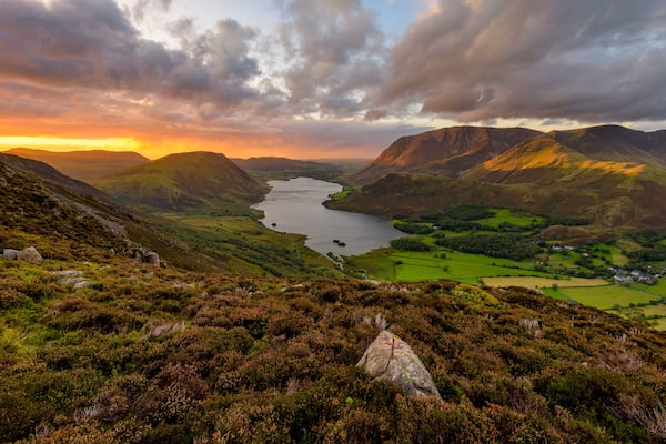 Moody dramatic clouds over high up view of Crummock Water at sunset. Lake District, UK.