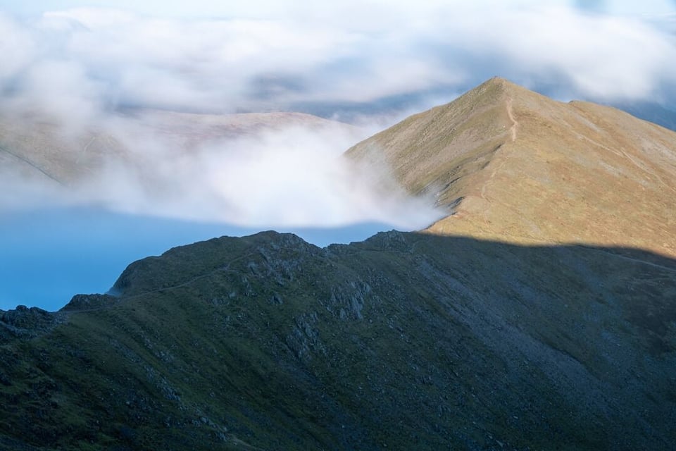 A mountain with a peak partially obscured by clouds.