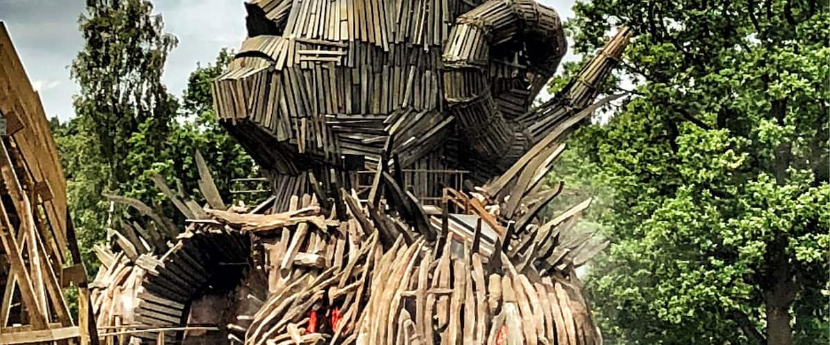 A wooden roller coaster with a large, rustic structure at the top.