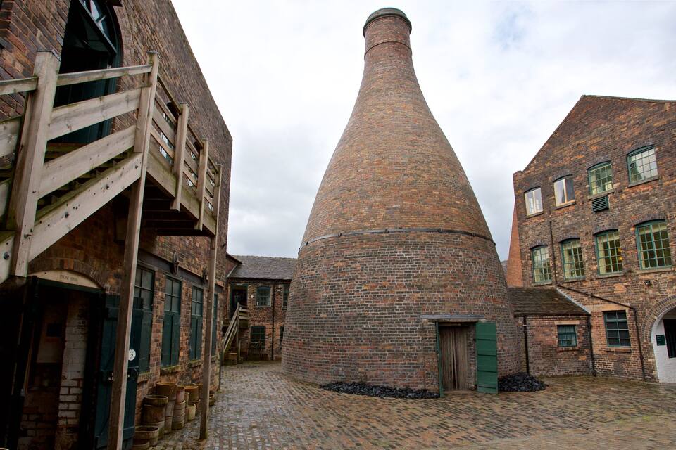 A brick building with a conical chimney, cobblestone street, and wooden structures.