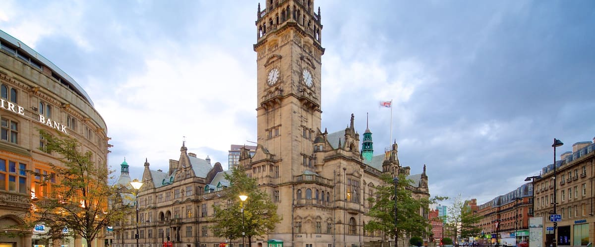 A historic building with a clock tower, surrounded by modern buildings and a clear sky.