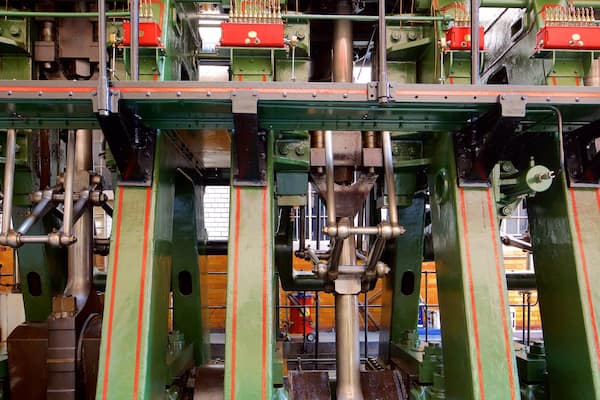 A complex industrial machine with green and red components, featuring multiple pipes and mechanical parts.