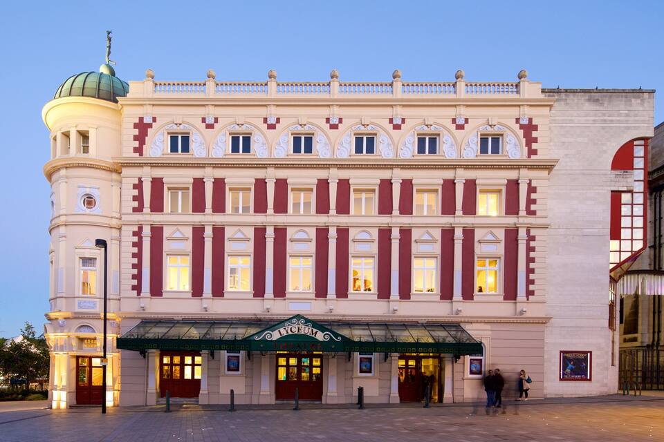 A historic theater building with a green marquee and a dome.