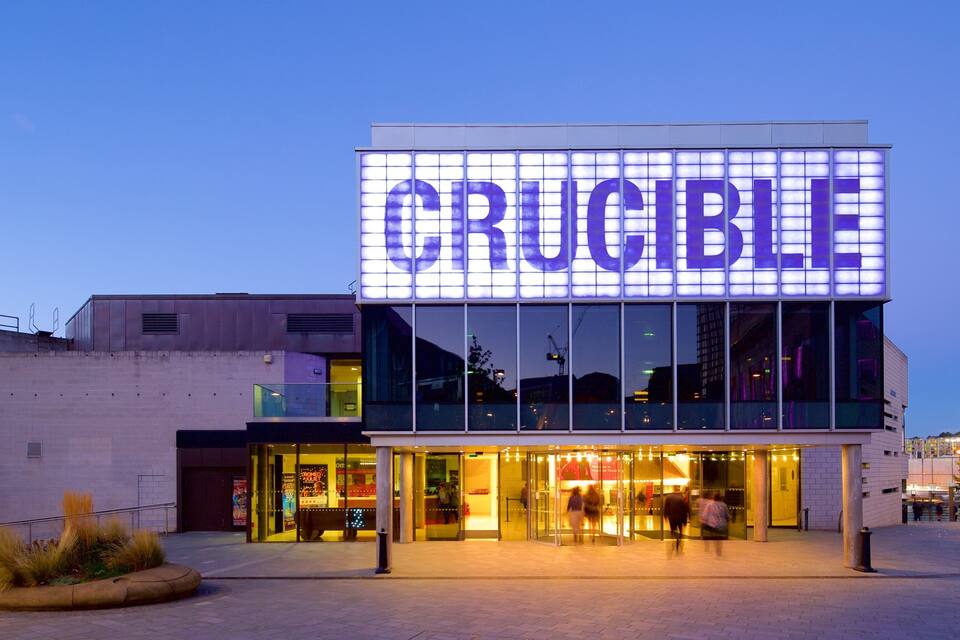 A building with a large illuminated sign reading "CRUCIBLE".