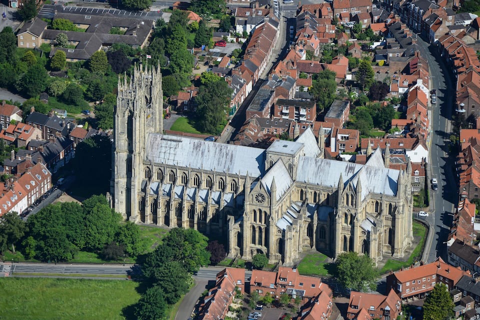 Una vista aerea di un'antica cattedrale circondata da edifici residenziali e spazi verdi.