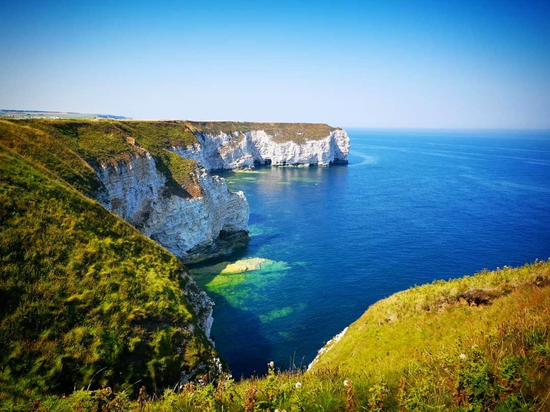 Flamborough Head is a promontory, 8 miles long on the Yorkshire coast of England, between the Filey and Bridlington bays of the North Sea. It is a chalk headland, with sheer white cliffs. The cliff top has two standing lighthouse towers, the oldest dating from 1669 and Flamborough Head Lighthouse built in 1806.