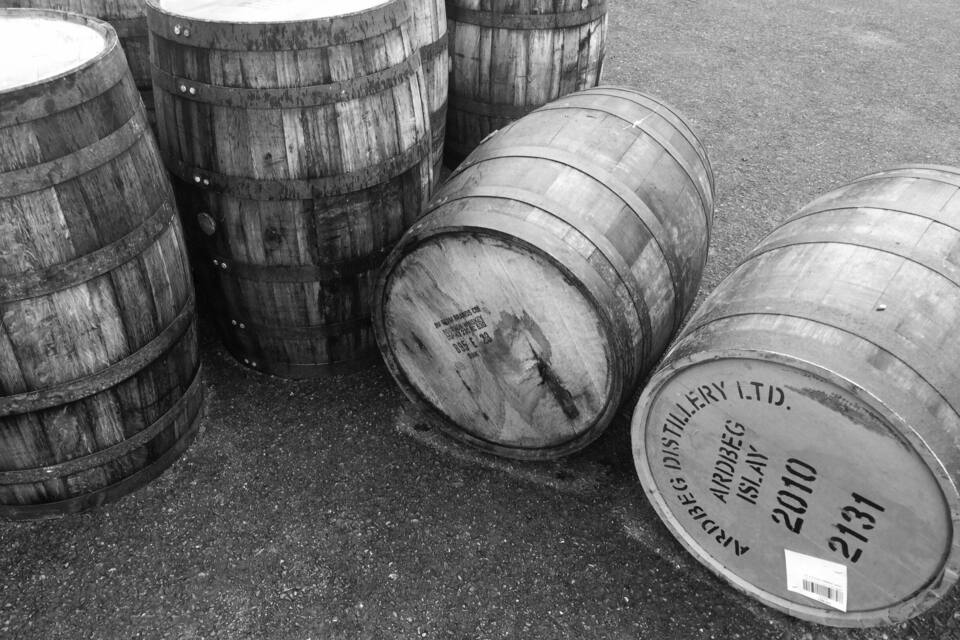 Several wooden barrels stacked on the ground.