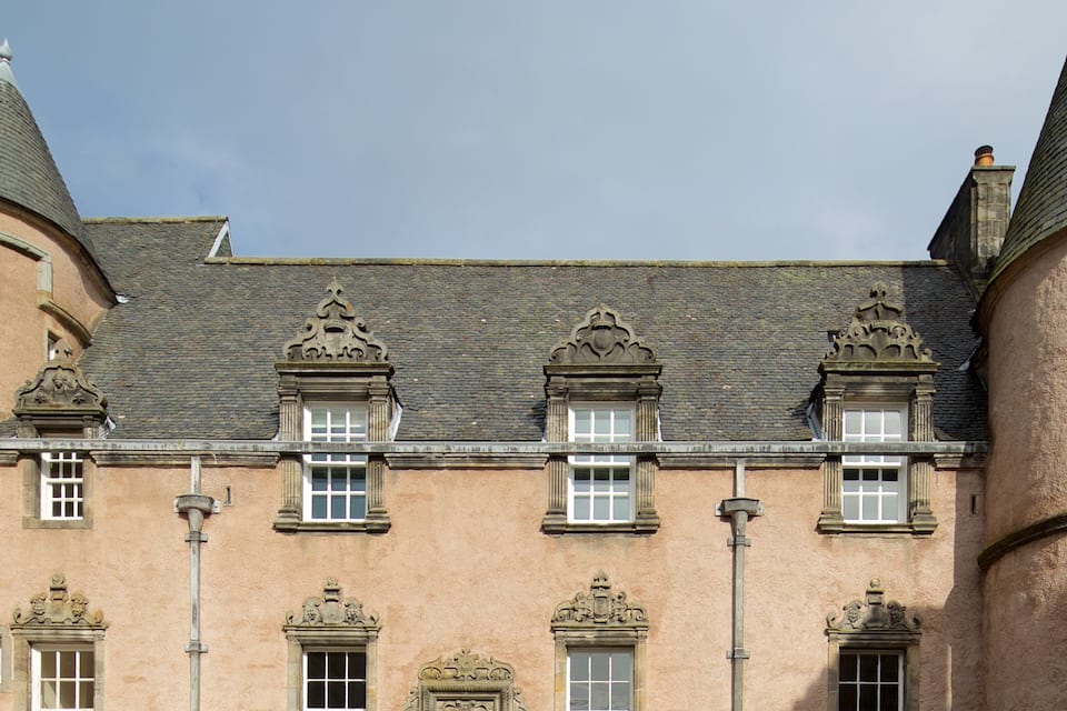 A historic building with ornate architectural details, including a steeply pitched roof and decorative window frames.