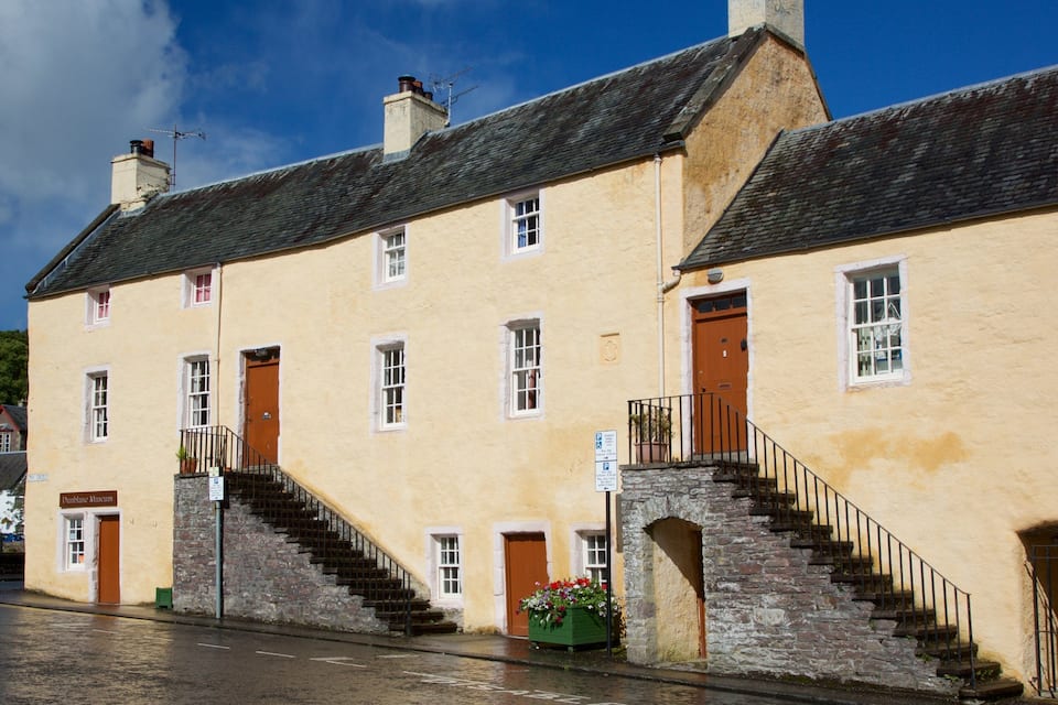 A historic building with a stone staircase and a wooden door.