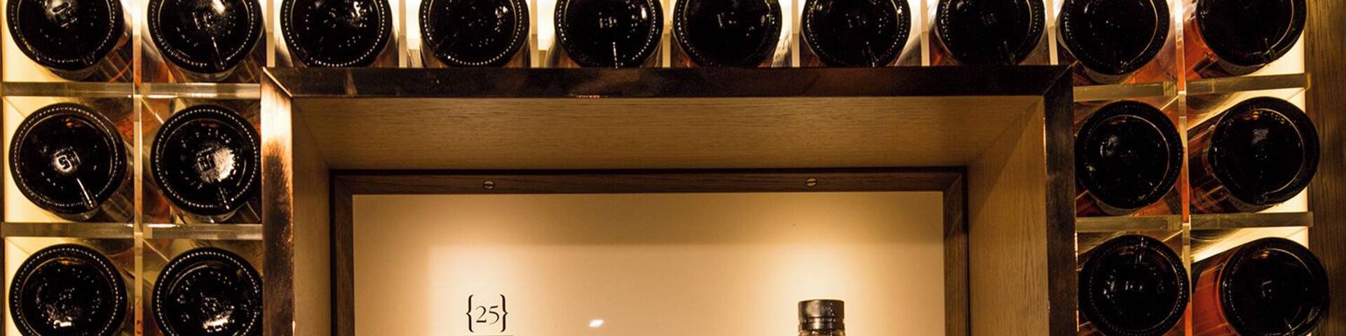 A bottle of Glenoyne whisky surrounded by a wall of empty bottles.