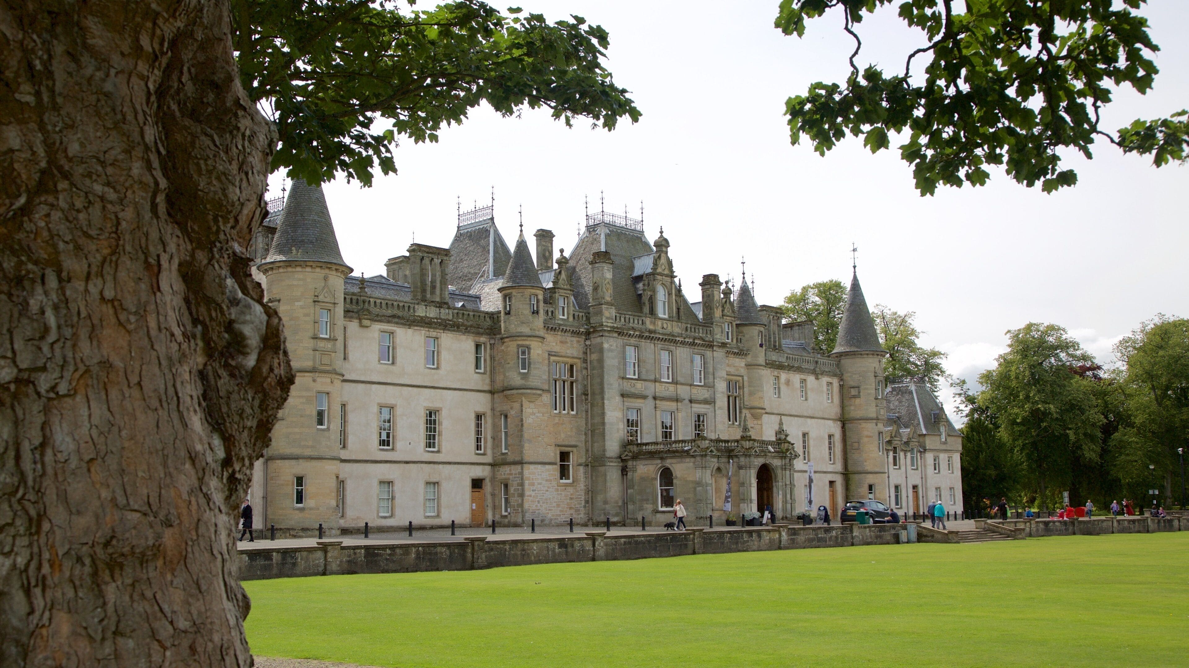 Un château historique doté de nombreuses tours et d’une pelouse bien entretenue.