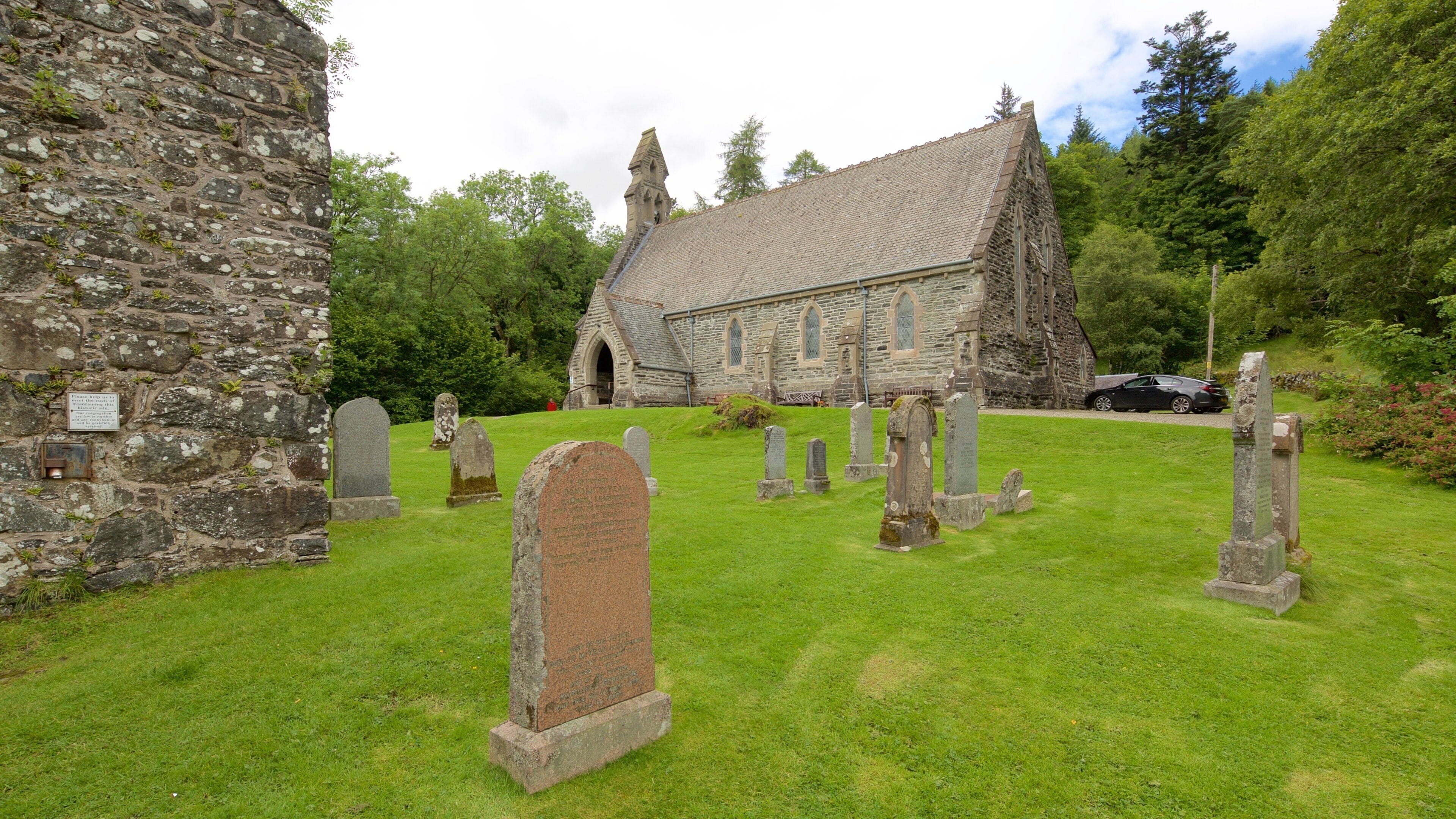 A church with a stone facade and a graveyard with headstones.