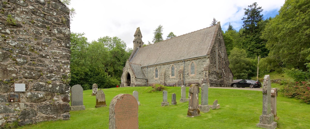 A church with a stone facade and a graveyard with headstones.