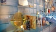 Un instrumento astronómico de bronce, posiblemente un telescopio, en una vitrina de museo.