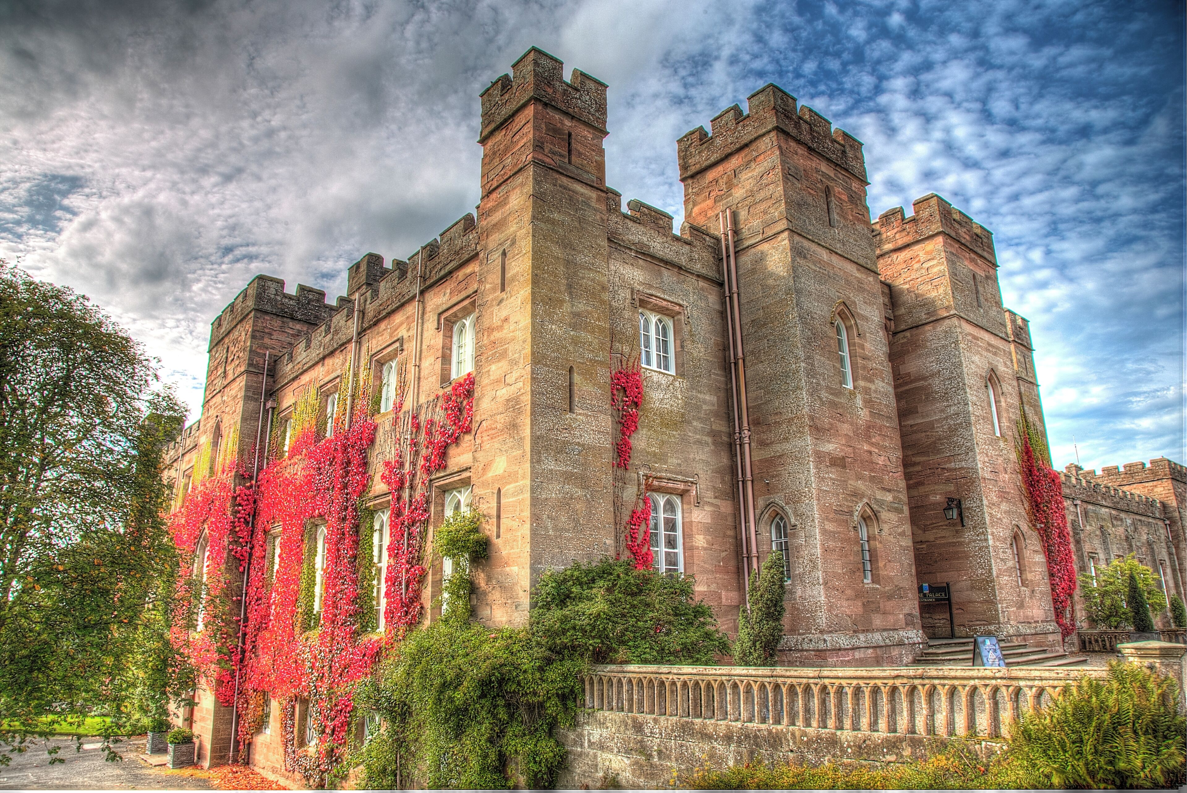 A historic castle with ivy-covered walls and multiple towers.