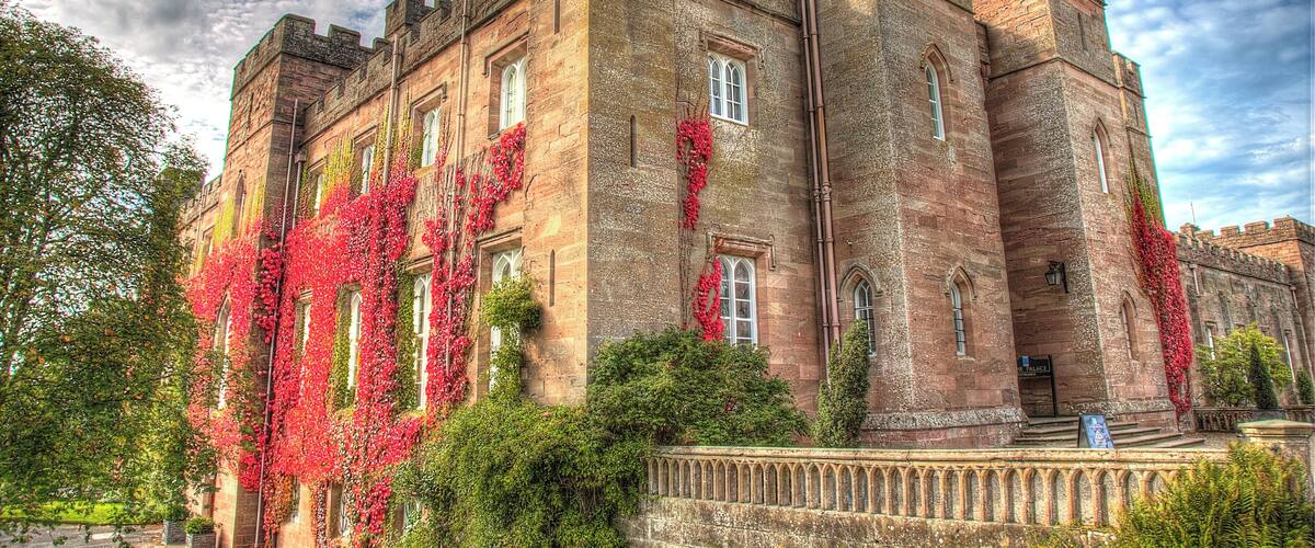 A historic castle with ivy-covered walls and multiple towers.
