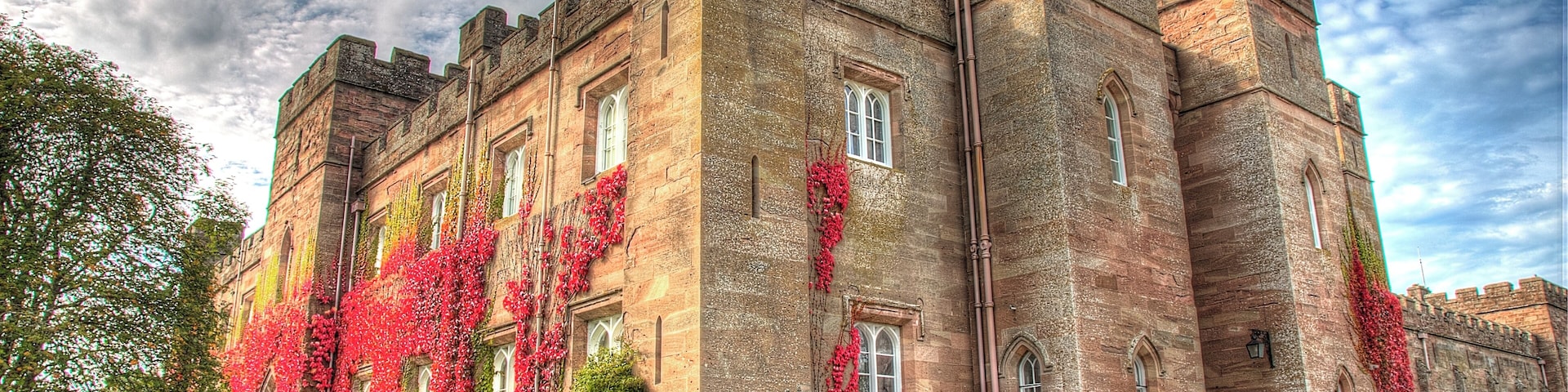 A historic castle with ivy-covered walls and multiple towers.
