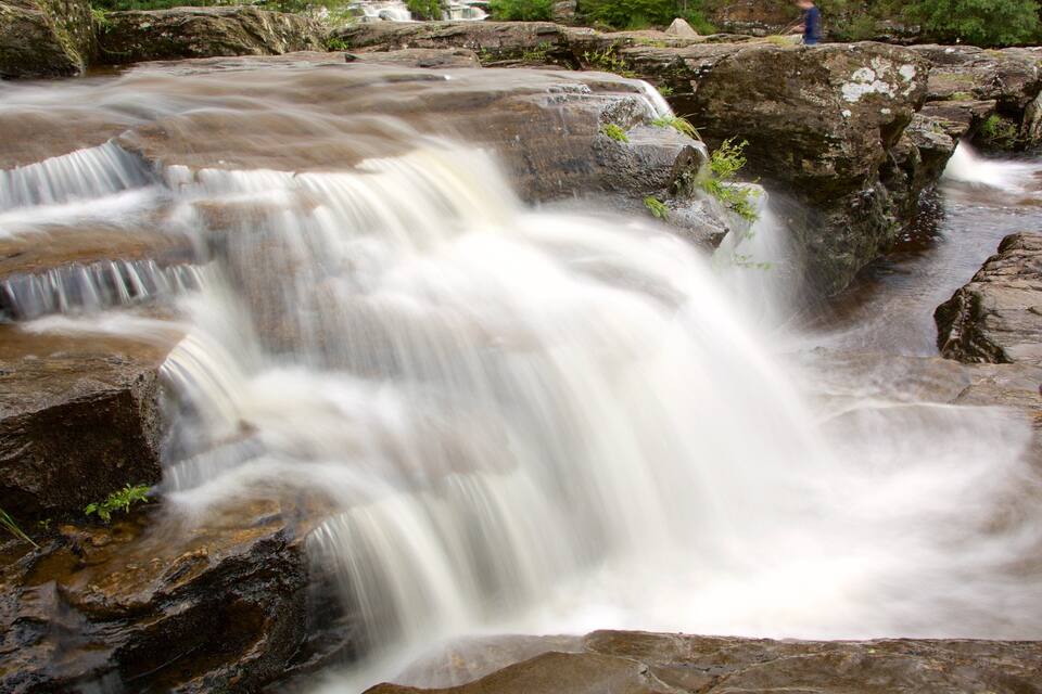 A waterfall cascading over rocks in a natural setting.