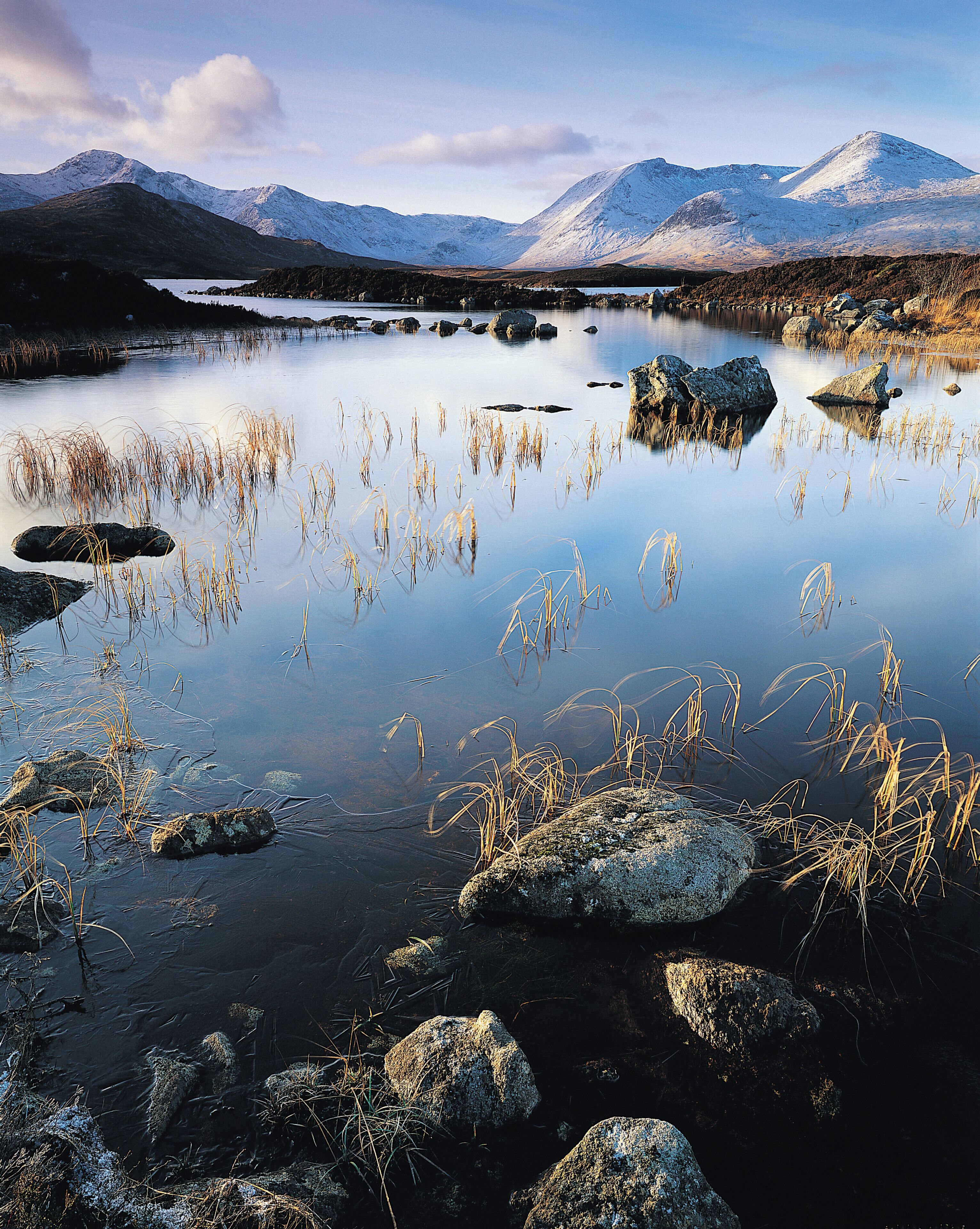 A calm lake surrounded by mountains and rocks.