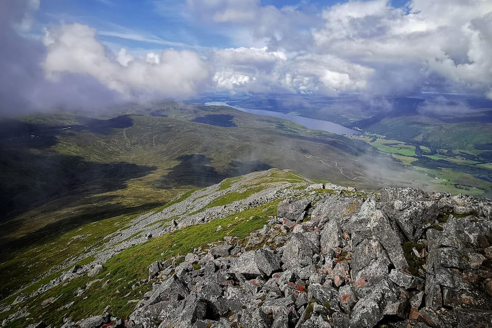 A mountainous landscape with rocky terrain and a valley below.