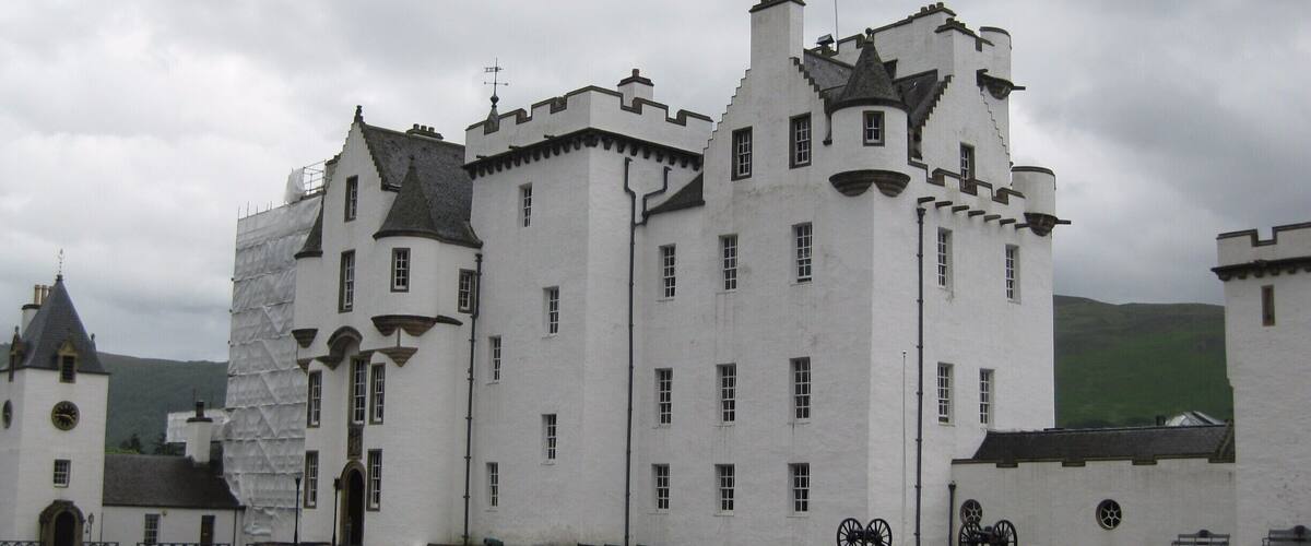 A large white castle with multiple towers and a flag.