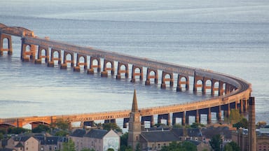 A large, arched bridge over a body of water, with buildings and a church in the foreground.