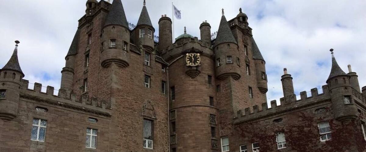 A large, historic castle with multiple towers and a central clock tower.