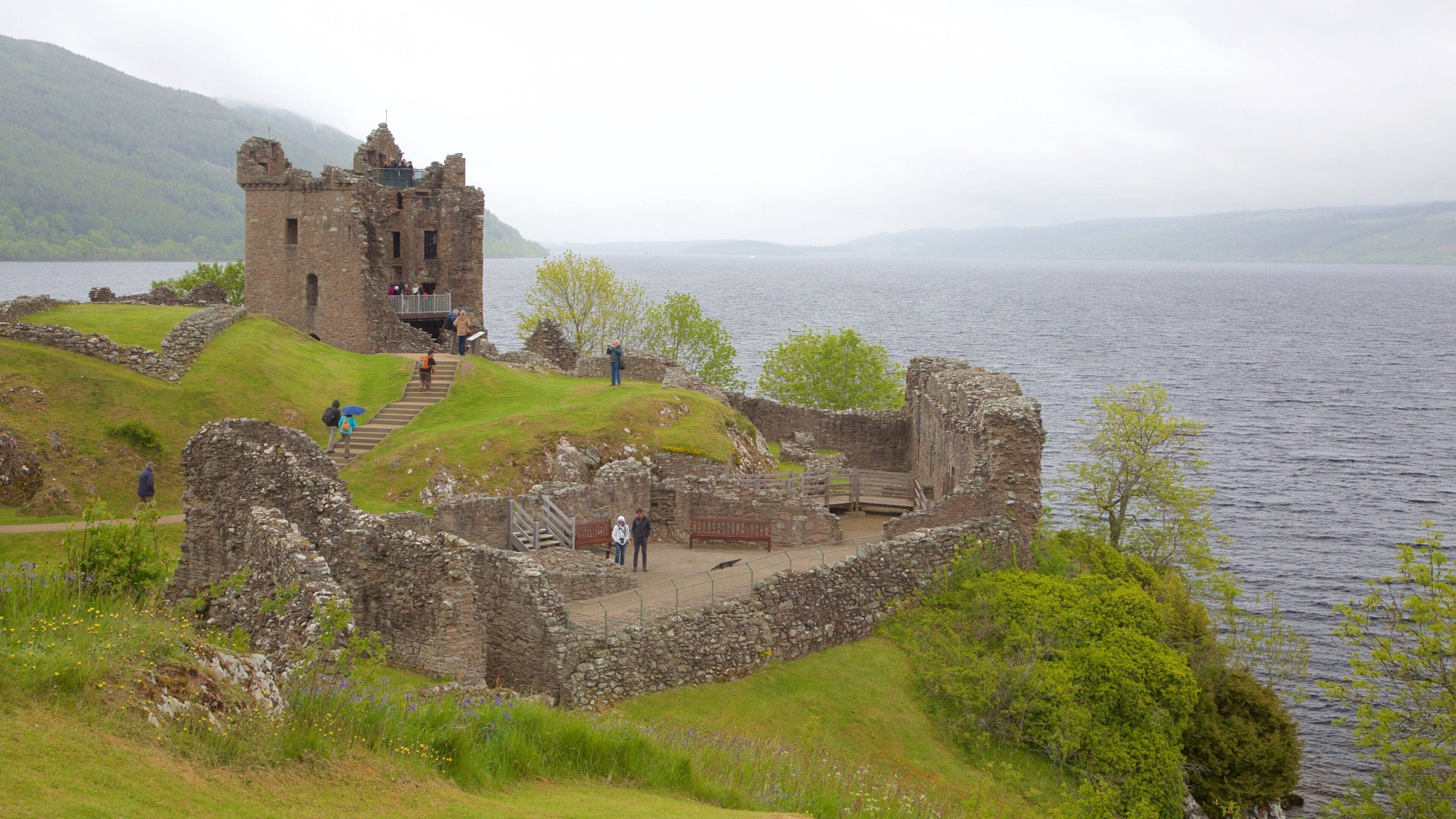 Urquhart Castle which includes building ruins, heritage elements and a lake or waterhole