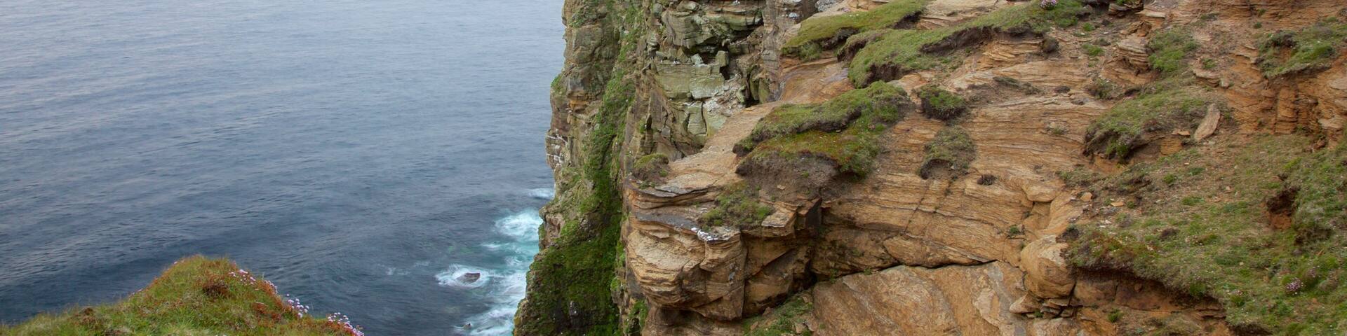 Dunnet Head Lighthouse featuring rugged coastline and a lighthouse