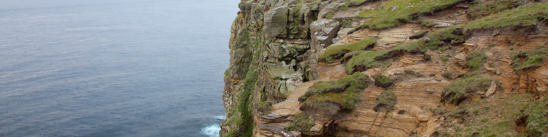 Dunnet Head Lighthouse which includes a lighthouse and rocky coastline