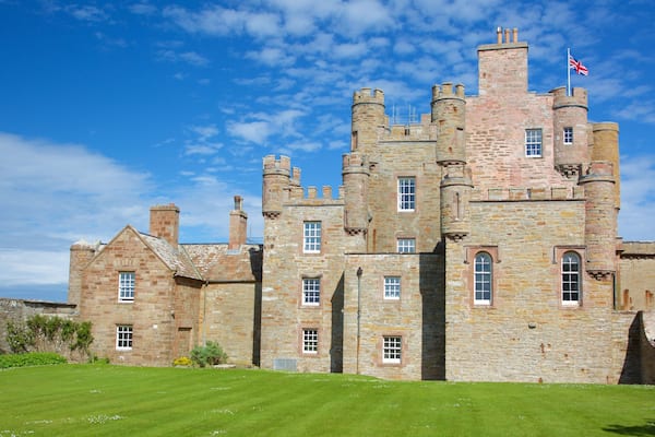 A large stone castle with multiple towers and a flag.