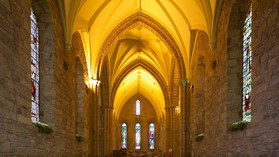 A cathedral interior with Gothic arches, stained glass windows, and stone walls.