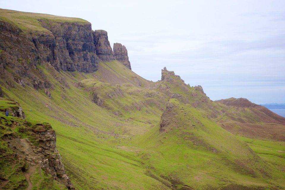 A rugged mountain landscape with steep cliffs and a valley.