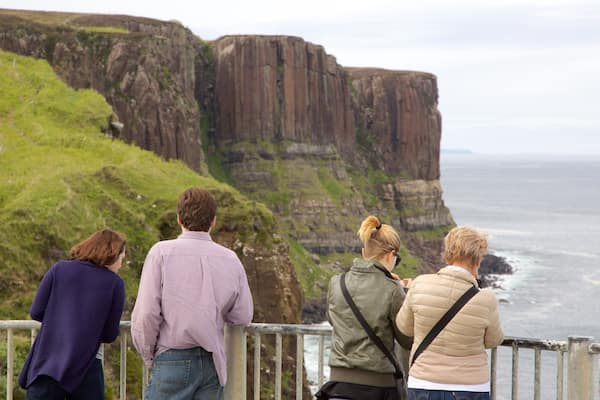 Kilt Rock featuring rocky coastline and views as well as a family