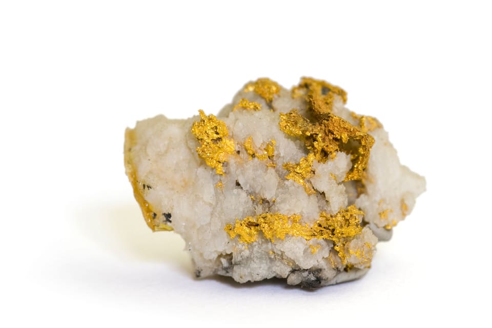 A close-up of a mineral with gold flecks on a white background.