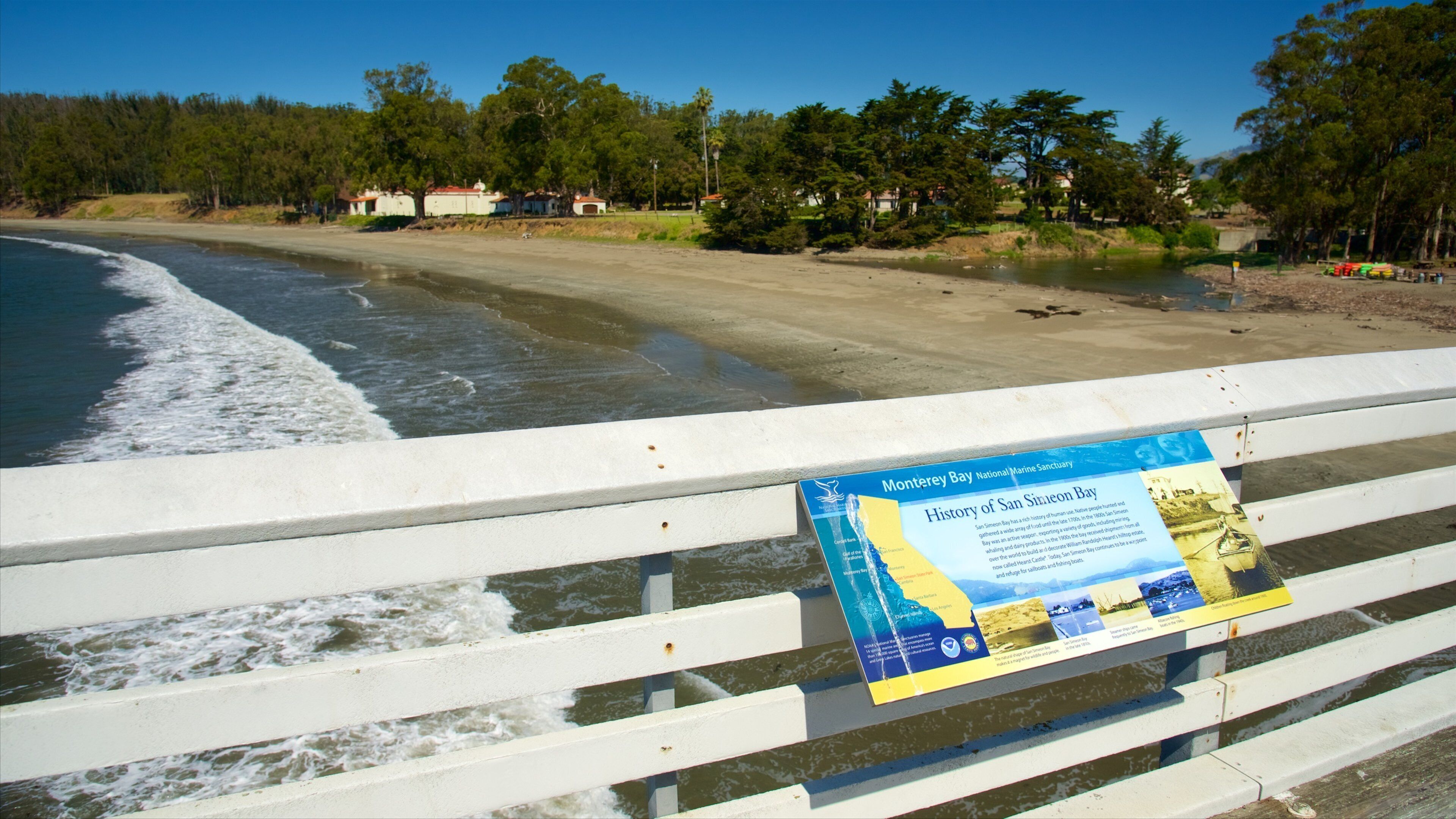 Una playa con un cartel sobre la Reserva Nacional de Marino de Monterey Bay.