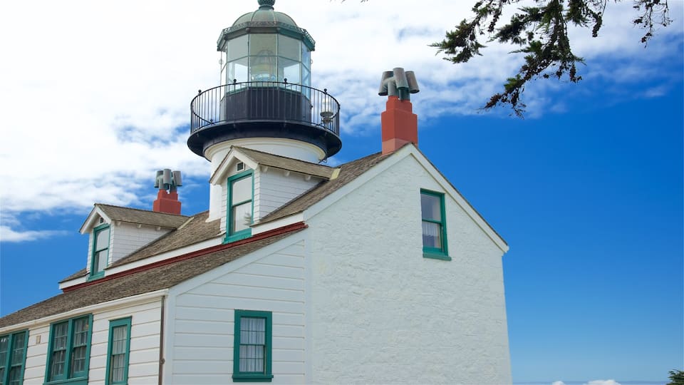 A white building with green trim and a lighthouse on top.