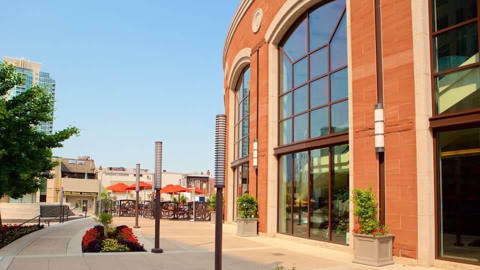 A brick building with large windows and outdoor seating.