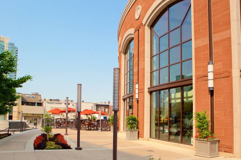 A brick building with large windows and outdoor seating.