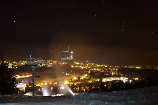 Une route enneigée, avec un télésiège visible au loin.