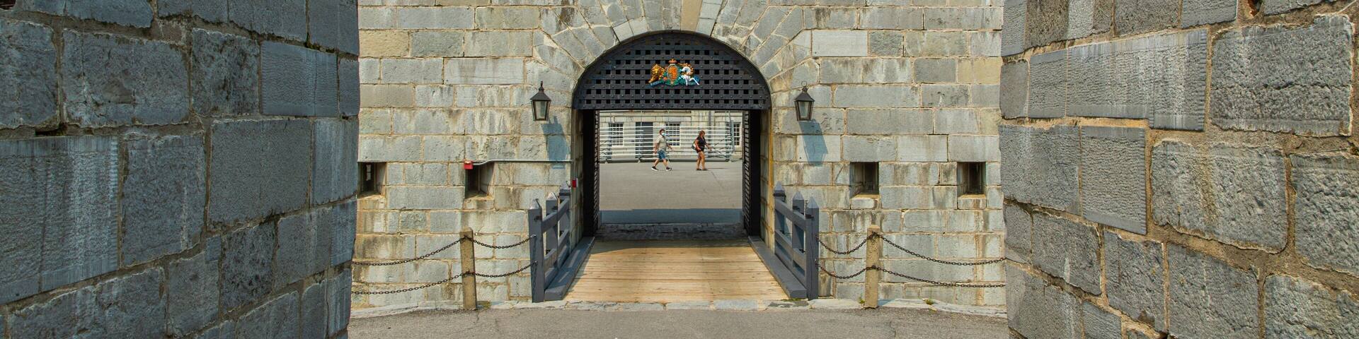 A stone gate with a plaque reading "Fort Henry 1832" and a coat of arms above the entrance.