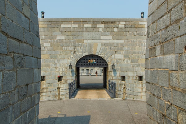 Ein Steintor mit einer Tafel, auf der "Fort Henry 1832" steht, und einem Wappen über dem Eingang.