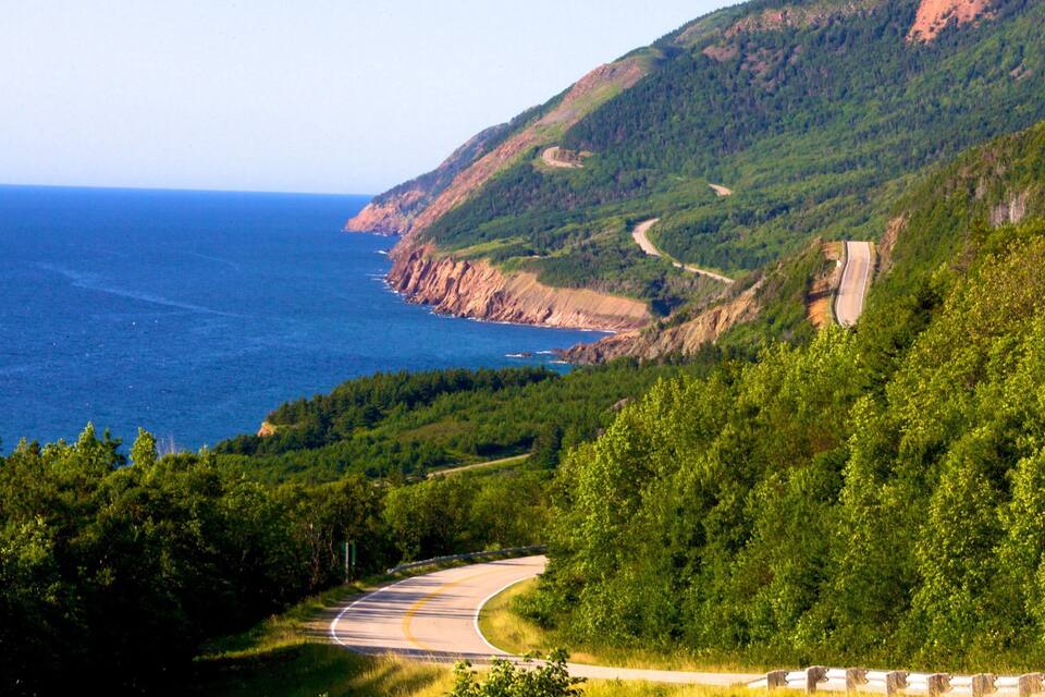 A winding mountain road with a coastal view.