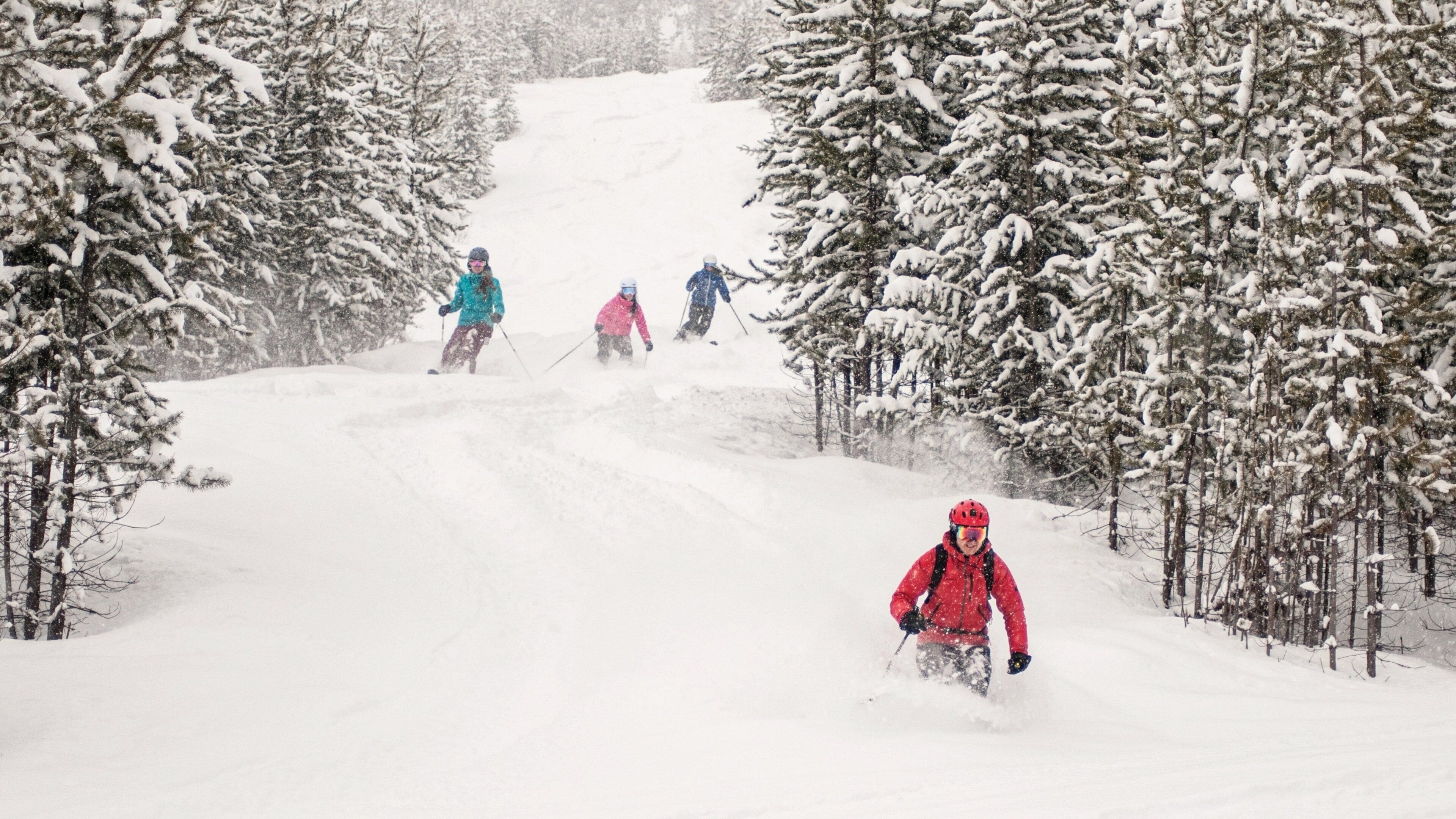 A snowy ski slope with skiers descending.
