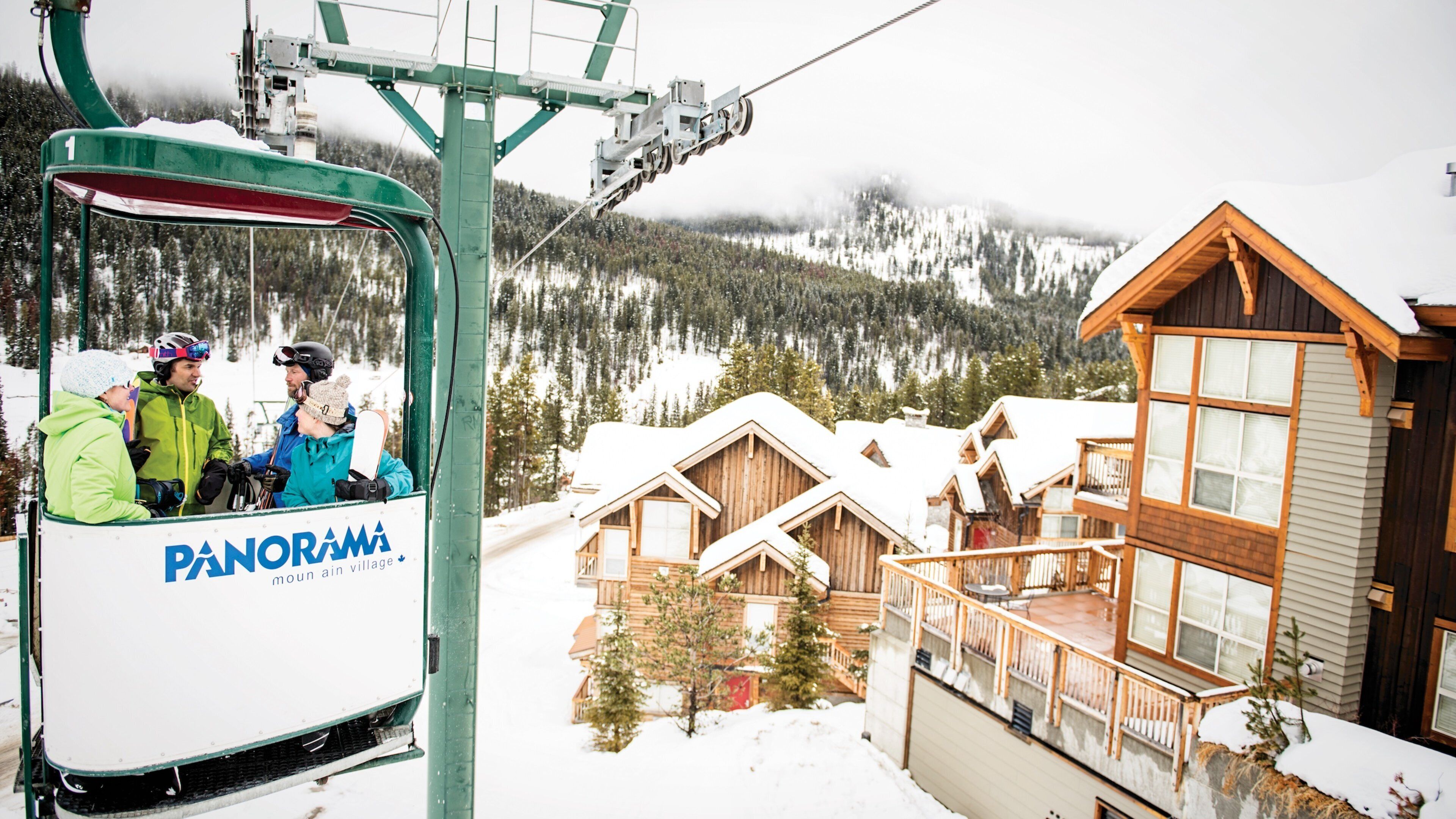 A ski lift with passengers, a wooden cabin, and a snowy mountain landscape.