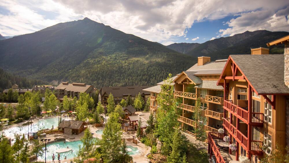 Un chalet de montagne doté d’une piscine et entouré d’une zone boisée.